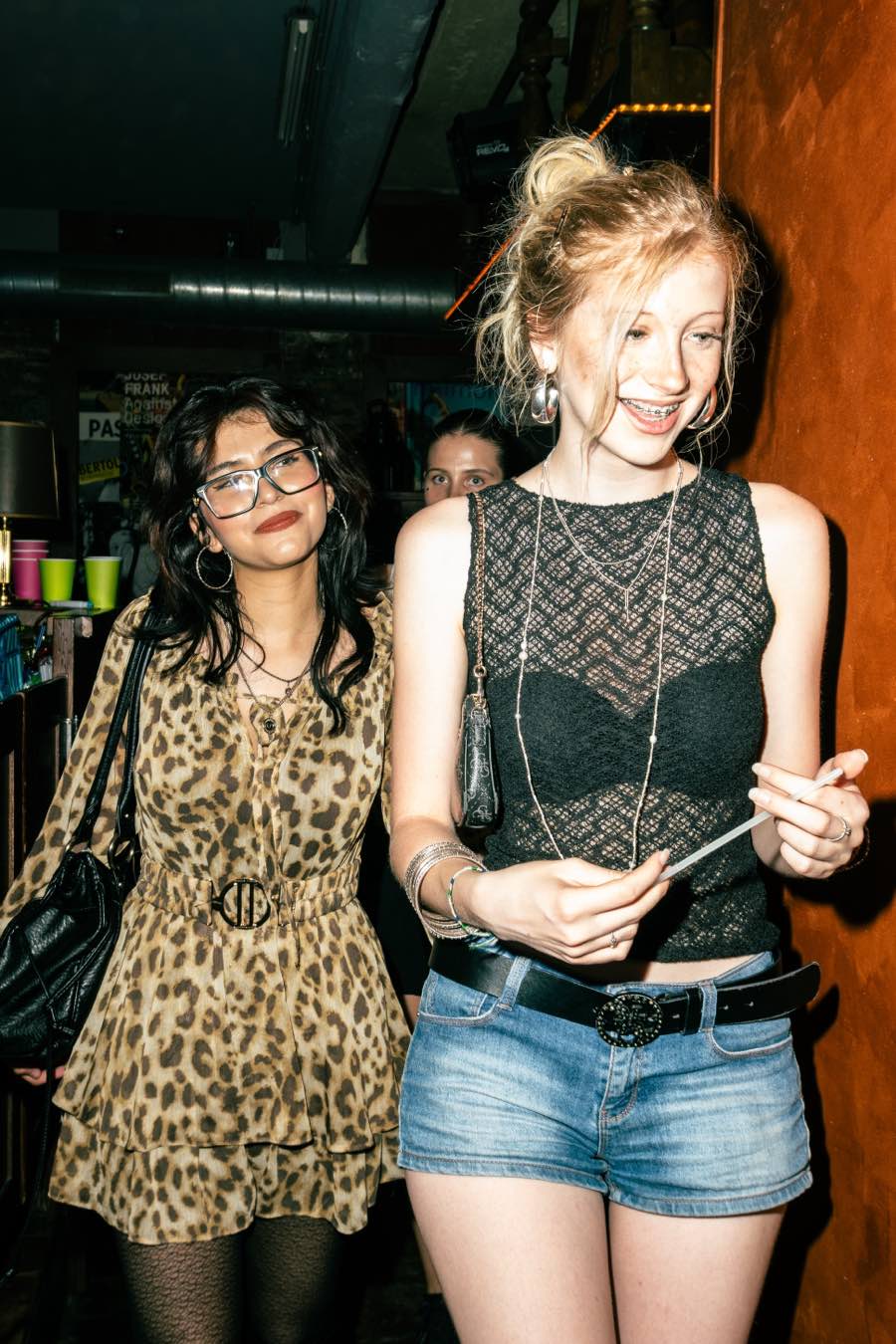 Two guests walking through the venue in leopard print and black lace.